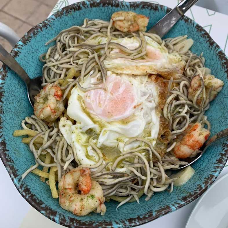 Huevos rotos con gulas y gambas