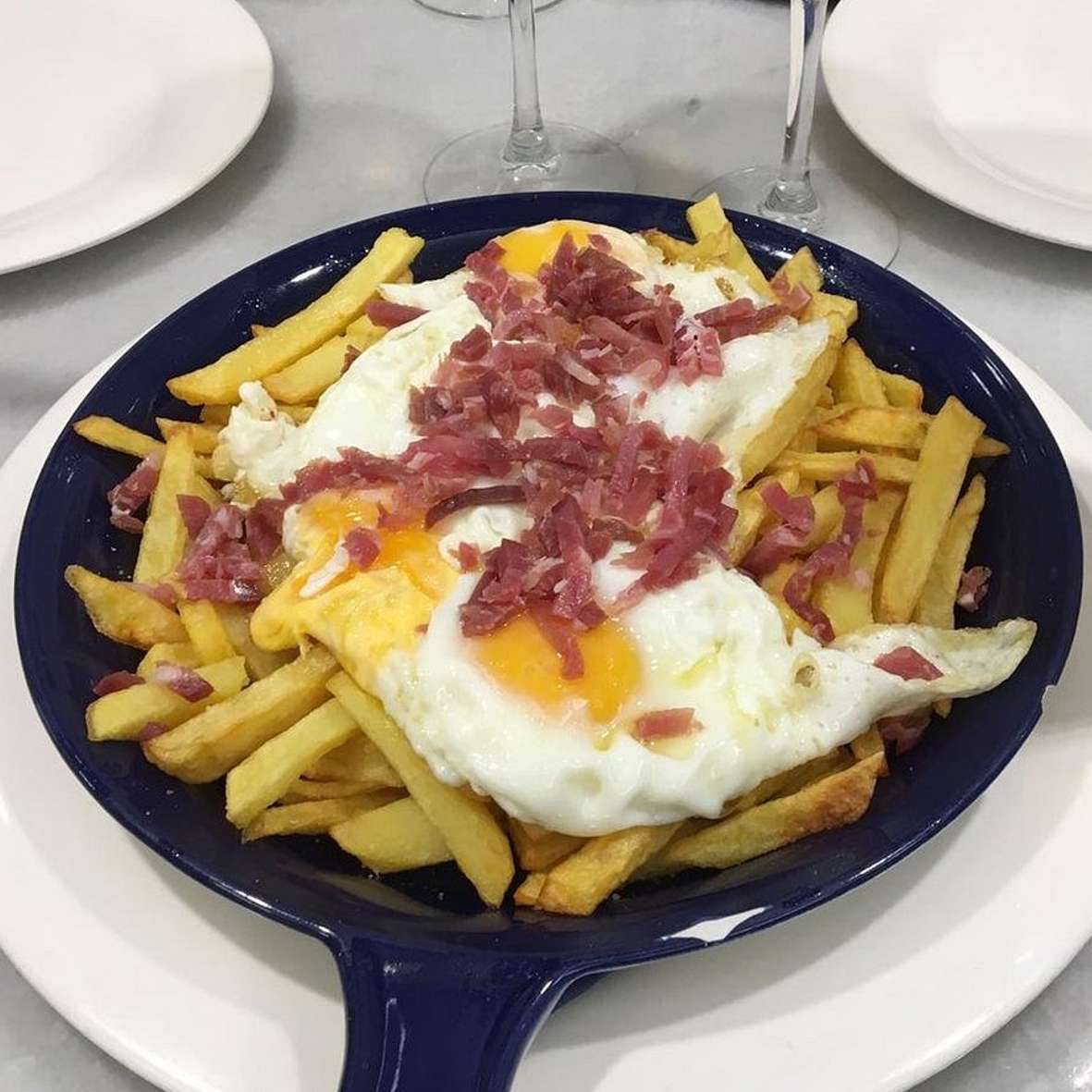 Huevos rotos con virutas de jamón