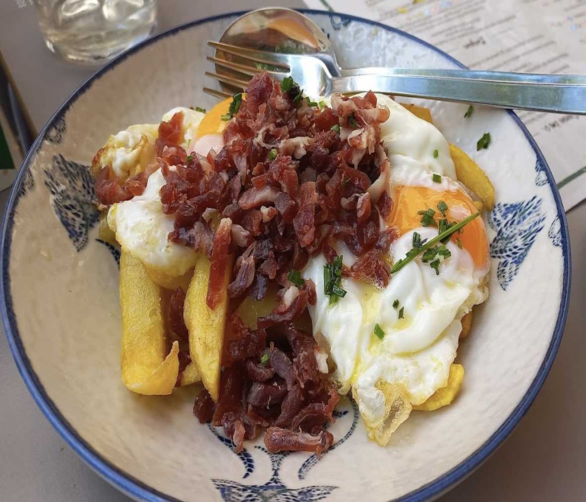 Huevos rotos con jamón picado con y patatas cortadas a mano