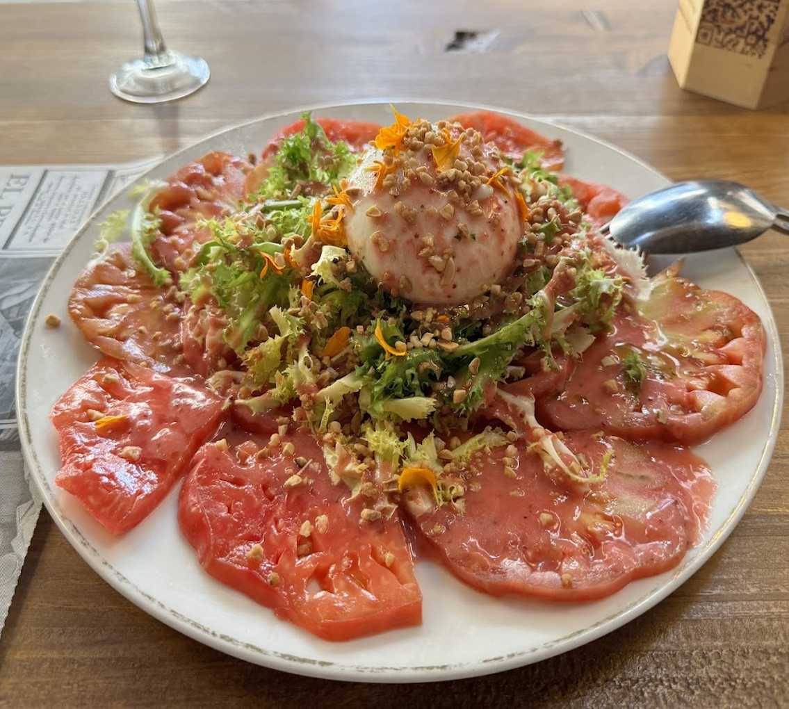 Ensalada de tomate rosa, escarola, burrata y vinagreta de fresas con almendra garrapiñada