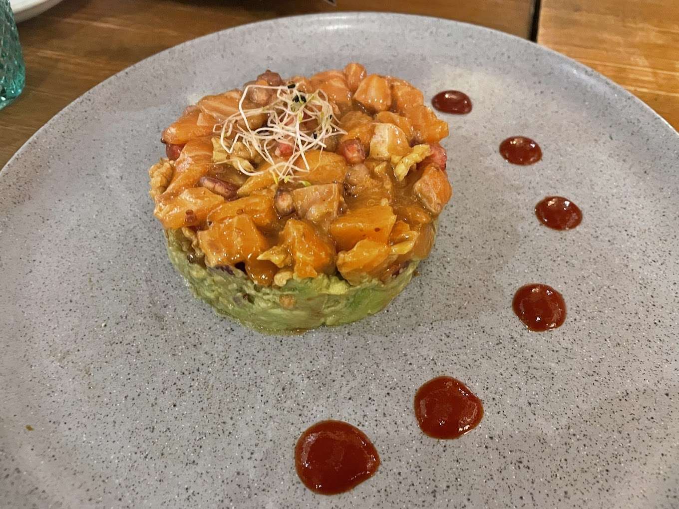 Tartar de salmón con granada y nueces sobre cama de aguacate